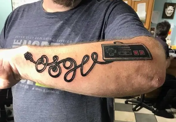 Brandon Perton has an Old School Game Vault tattoo written in NES cord.
